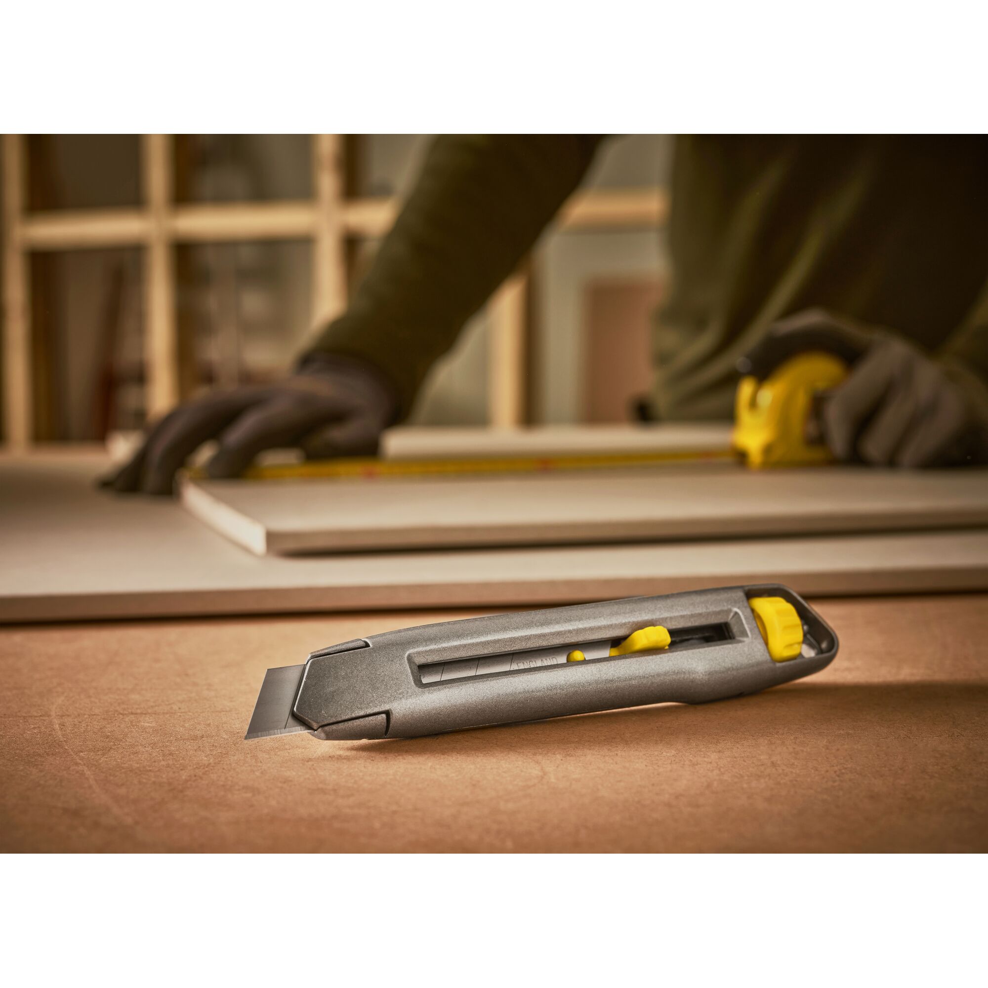 STANLEY 0-10-018 utility knife with retractable blade on worktable, construction scene.