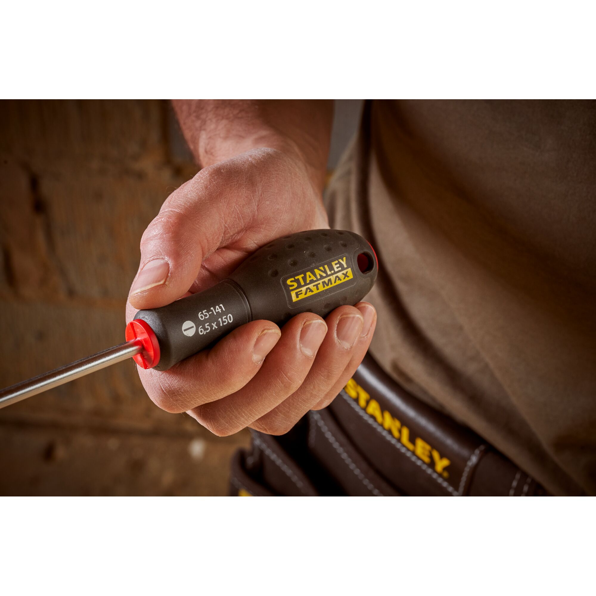 Photo of STANLEY 0-65-141 screwdriver with black and yellow handle, held in hand, close-up view.