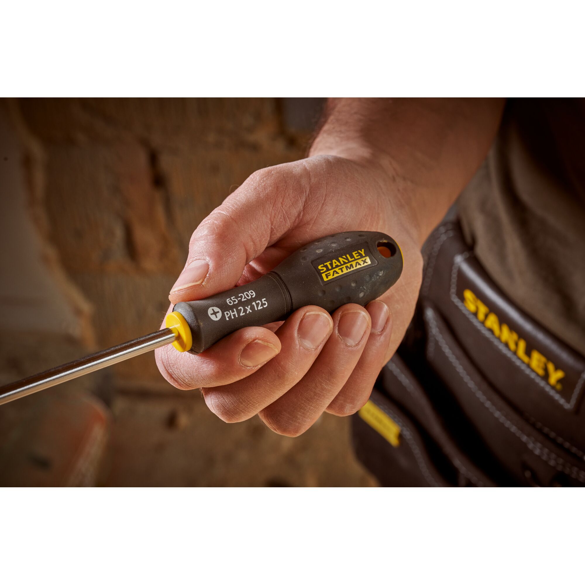 Photo of STANLEY 0-65-209 screwdriver with black and yellow handle, held in hand, close-up view.