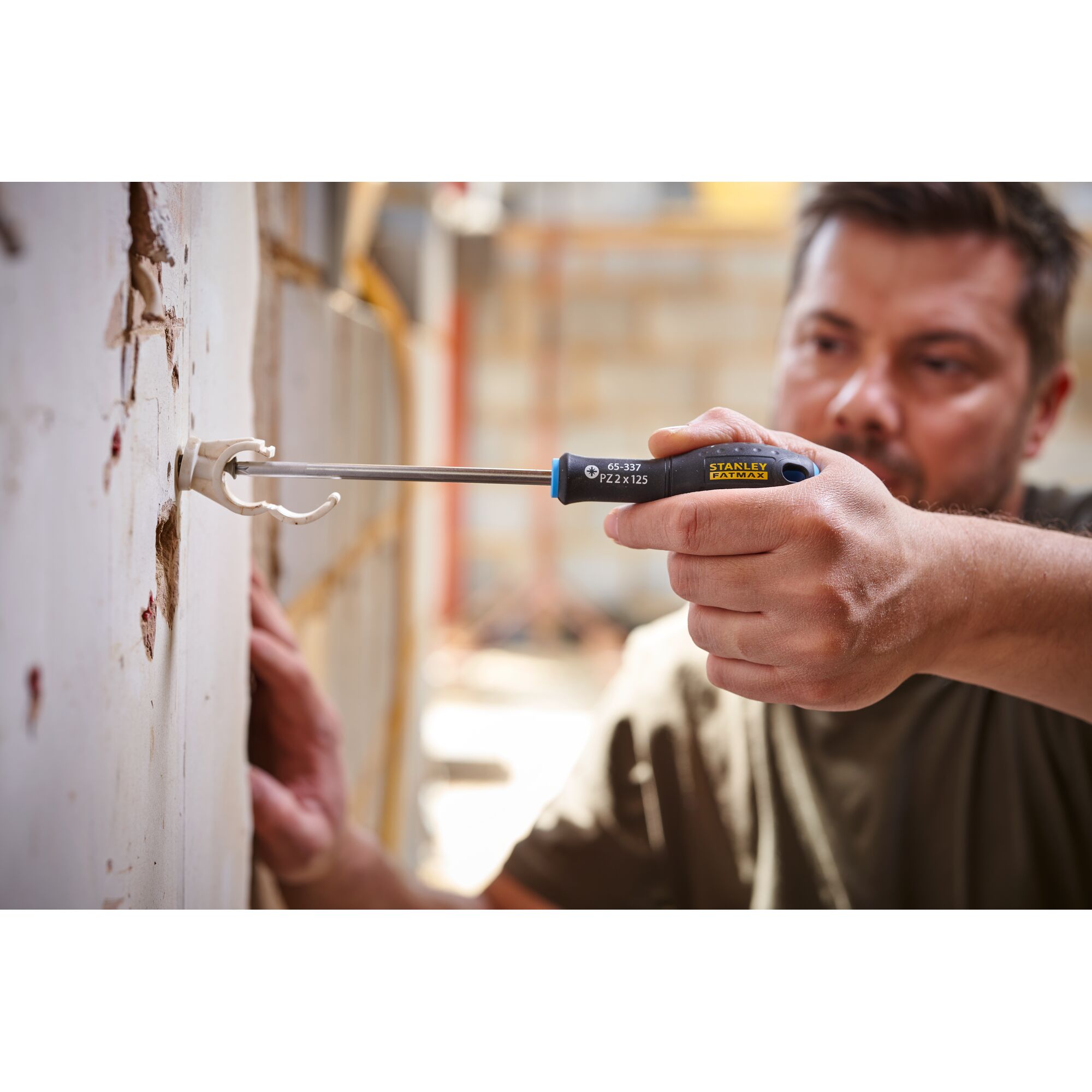 Photo of STANLEY 0-65-337 screwdriver used to install fixture in drywall, close-up view.
