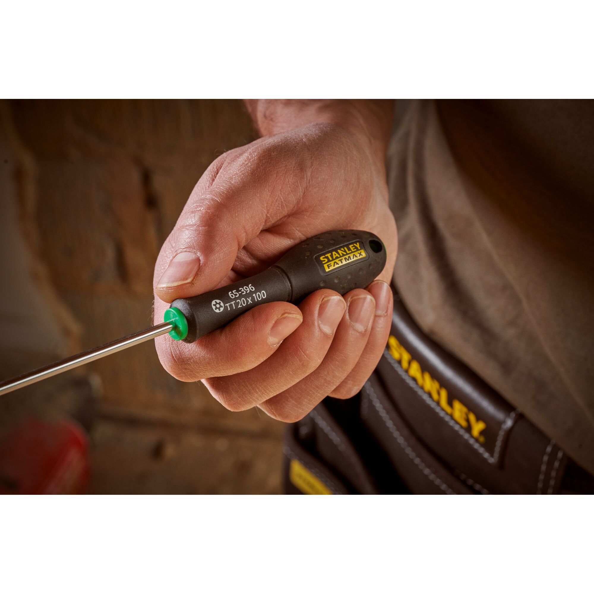Photo of STANLEY 0-65-396 screwdriver with black and yellow handle held in hand, tool pouch in background.
