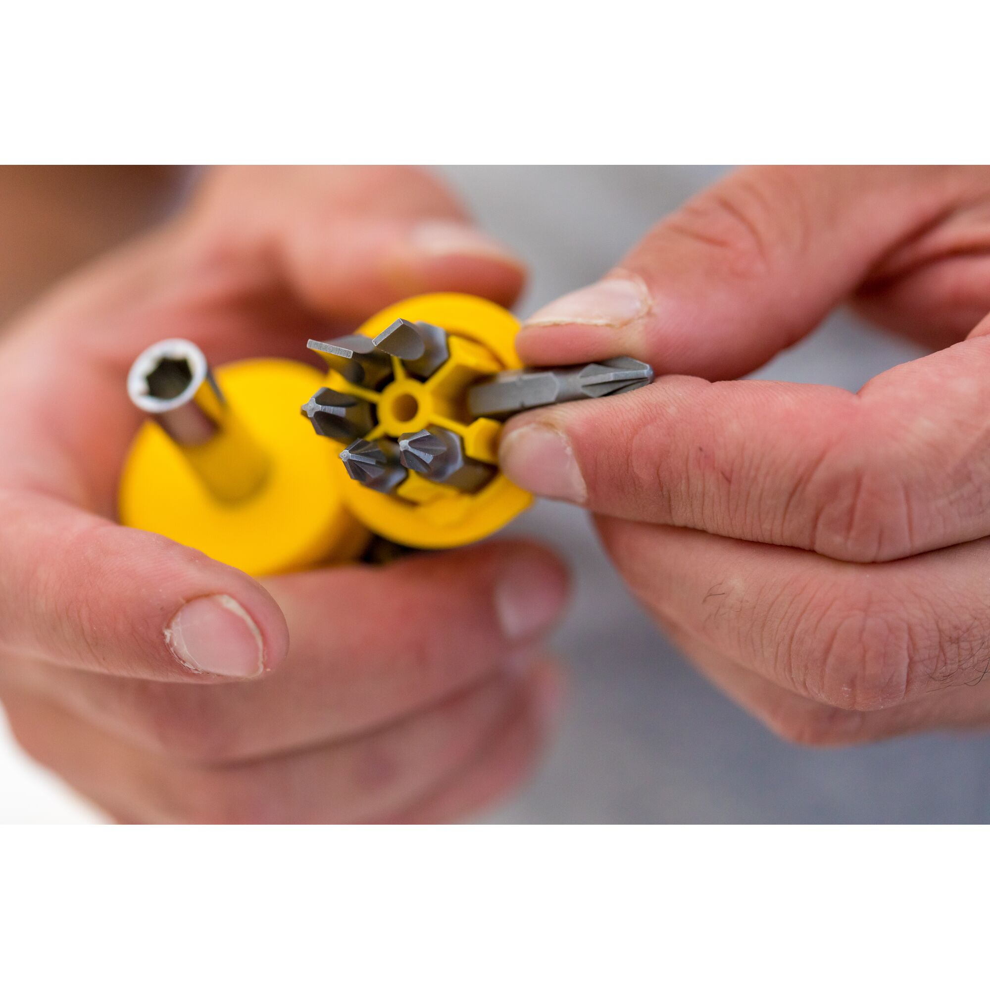 STANLEY 0-66-357 screwdriver set with yellow handle and multiple interchangeable bits shown in hand, close-up.