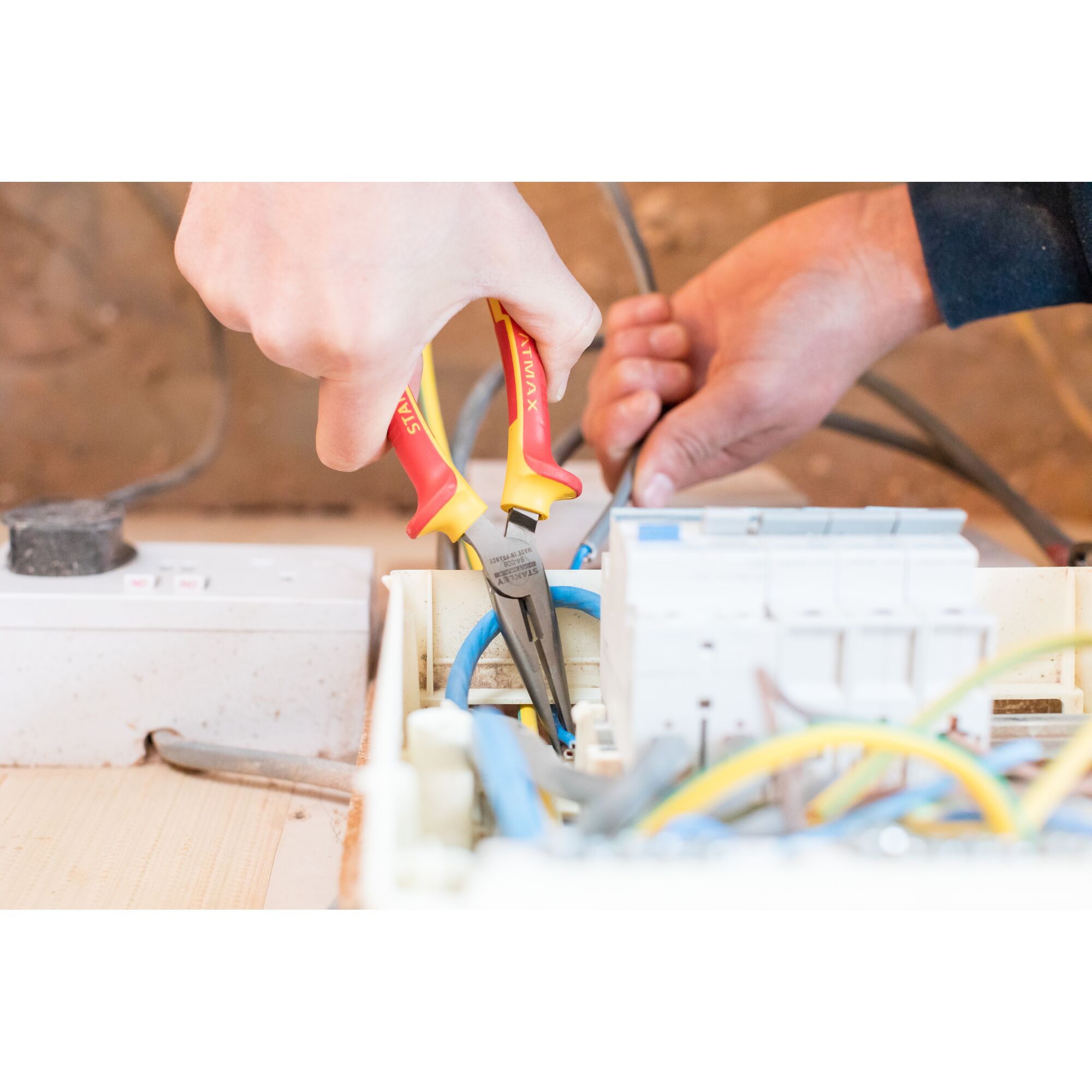 Photo of STANLEY 0-84-006 insulated pliers being used on electrical wiring in a control panel.