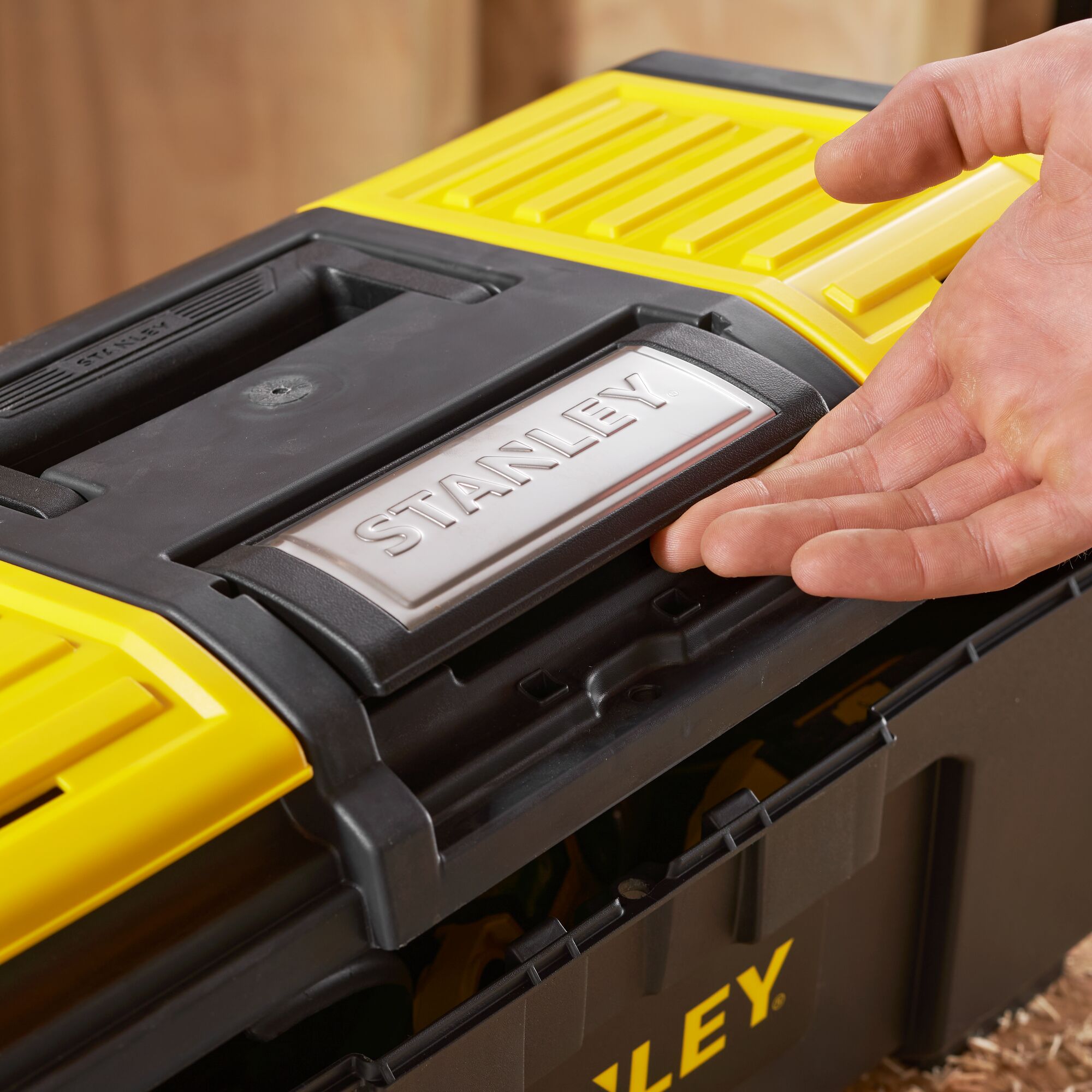 Photo of STANLEY 1-79-217 black and yellow toolbox with handle detail, shown being opened.