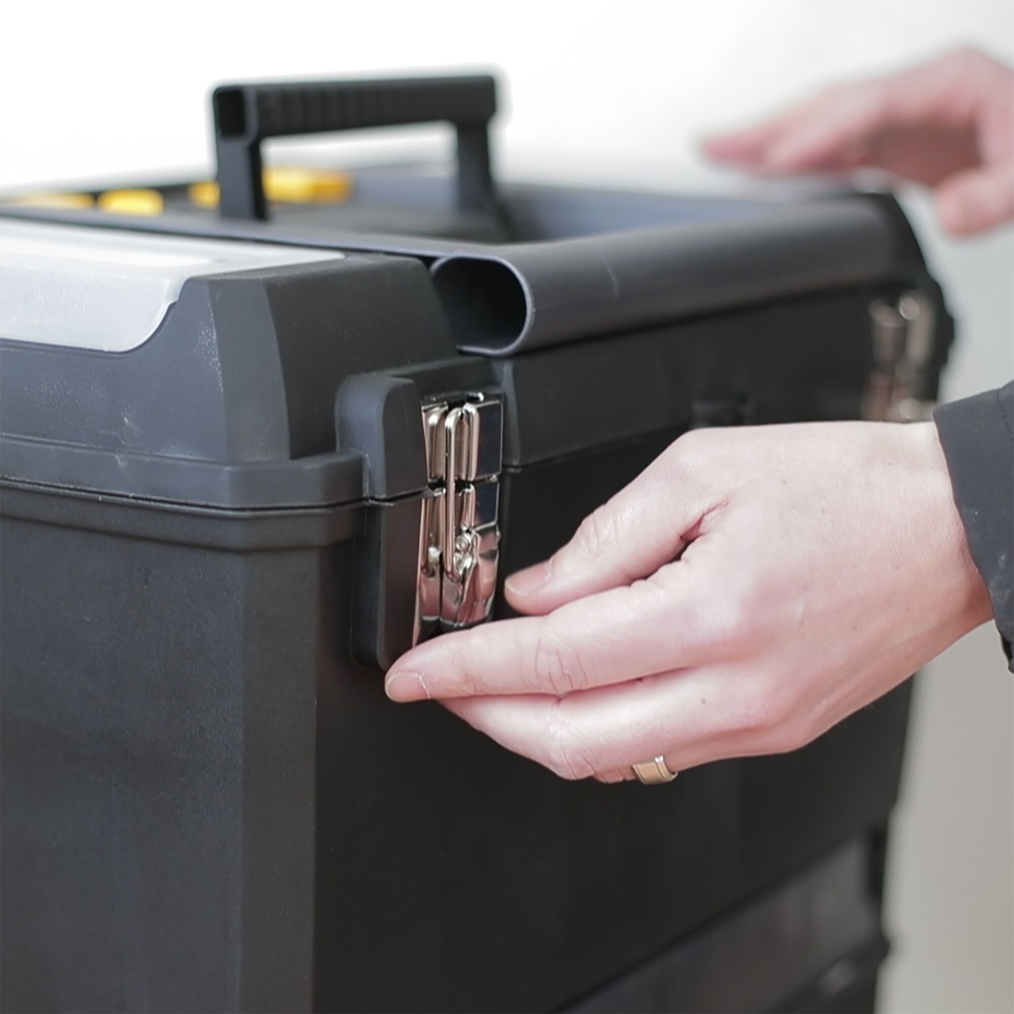 STANLEY 1-93-968 black toolbox with silver latch being opened, close-up photo of product in use.