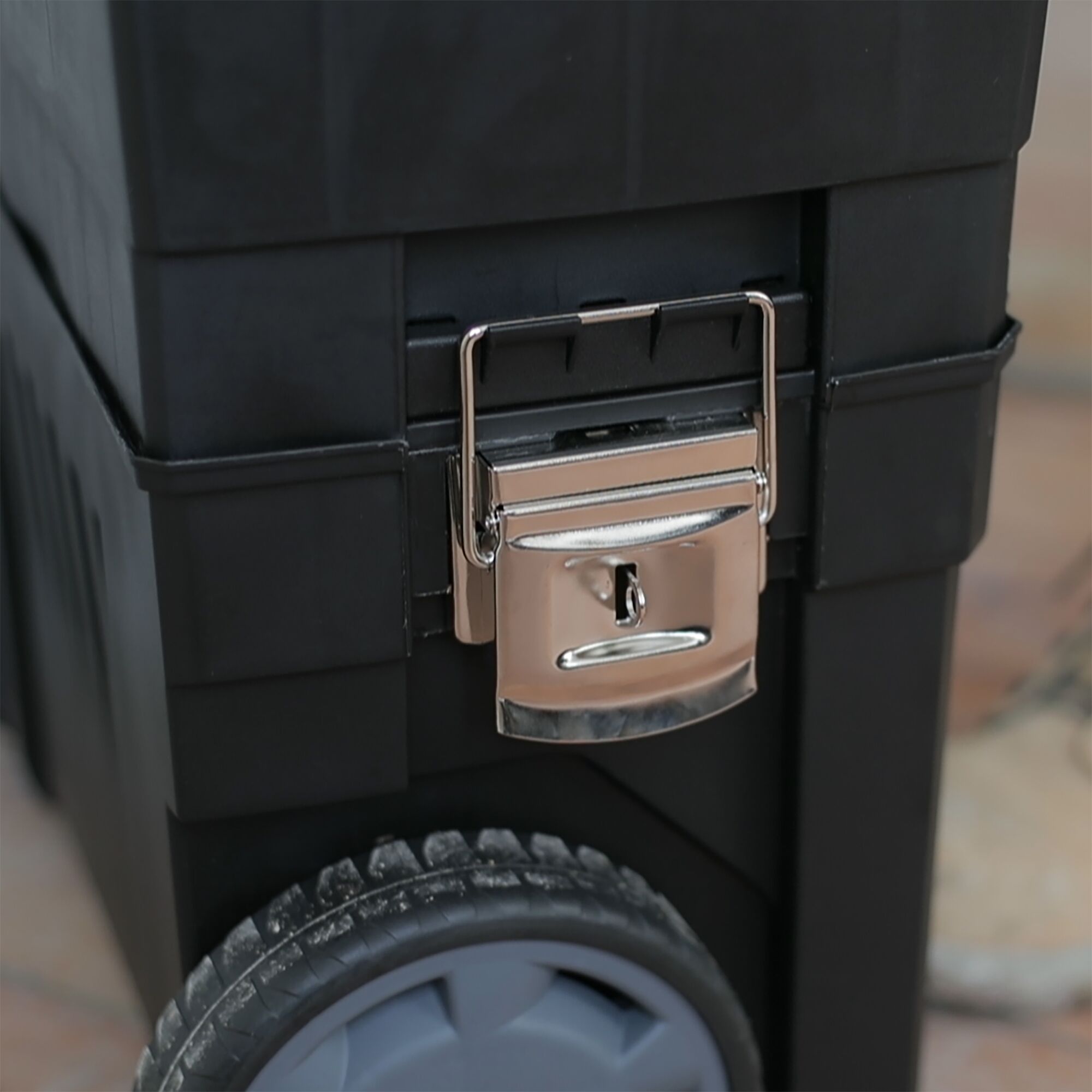 STANLEY 1-93-968 tool box close-up, showing metal latch and black plastic body with wheel.
