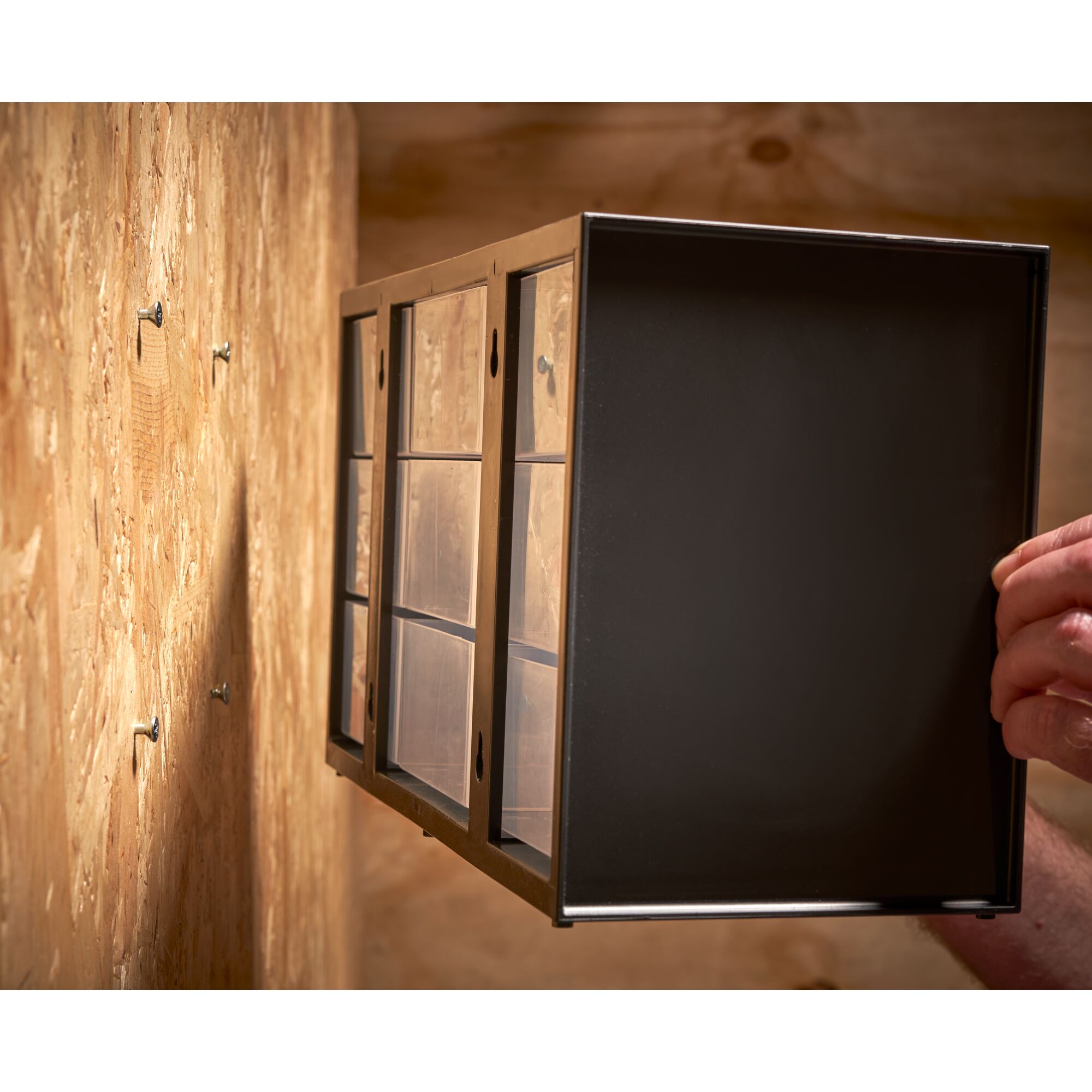 STANLEY 1-93-978 storage drawer cabinet being mounted on a wooden wall, angled side view.