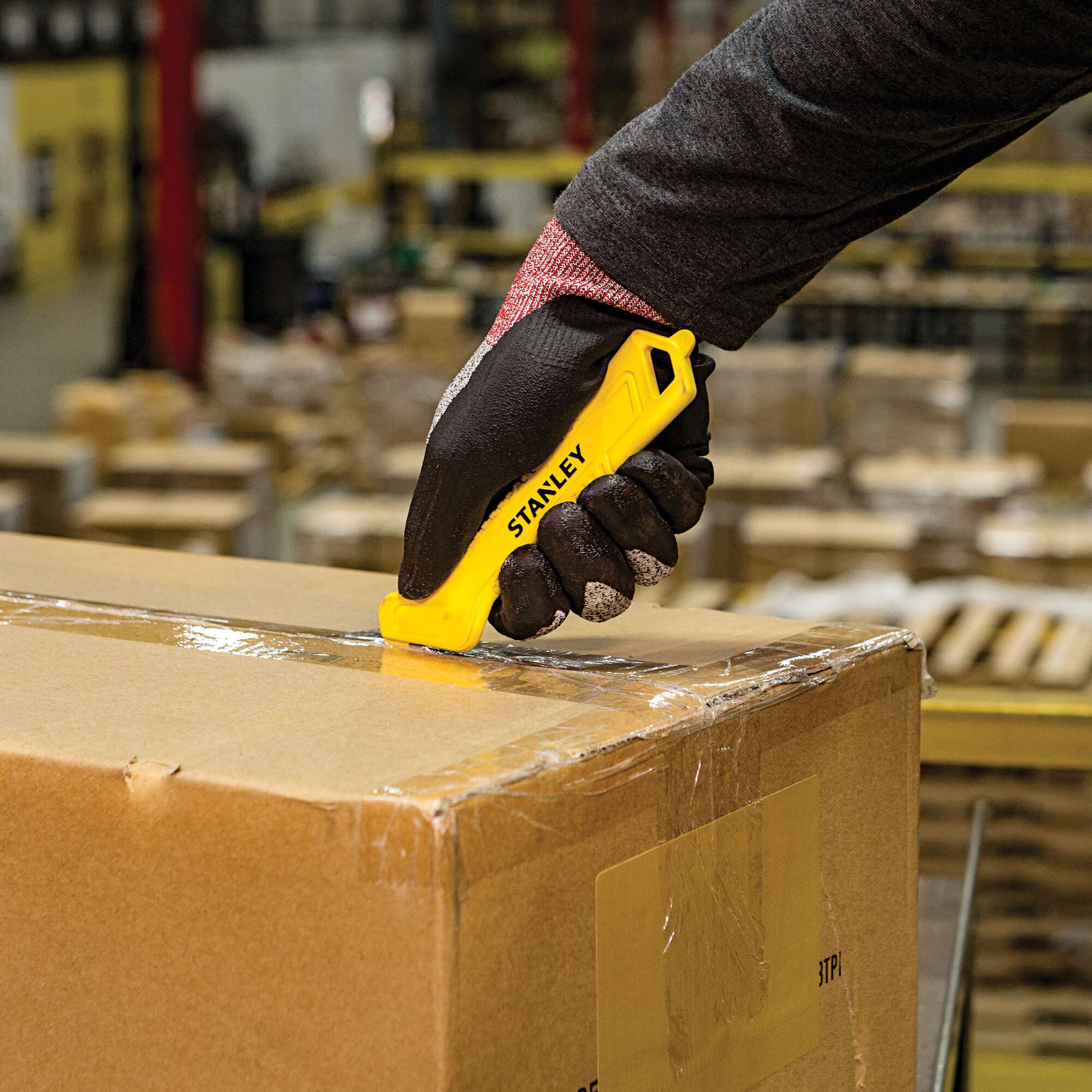 Single Sided Pull Cutter being used for cutting cello tape on cardboard box.