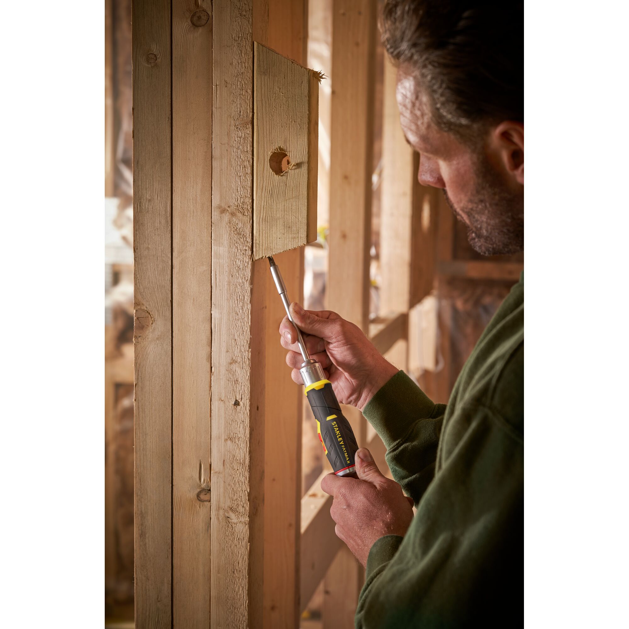 Photo of STANLEY FMHT0-62691 ratcheting screwdriver being used to fasten a screw into wooden framing.