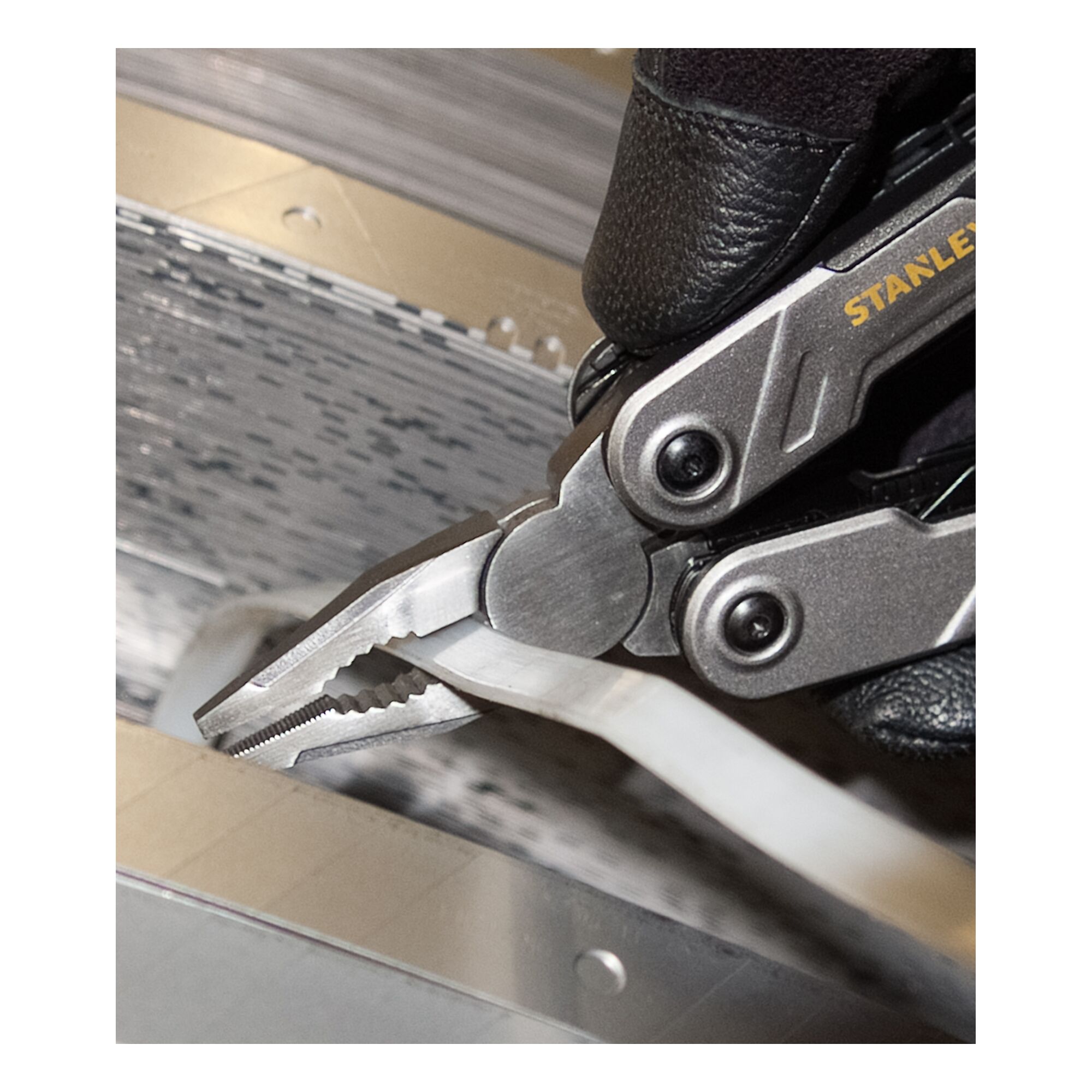 STANLEY FMHT0-72414 multitool pliers gripping a white cable, close-up photo.