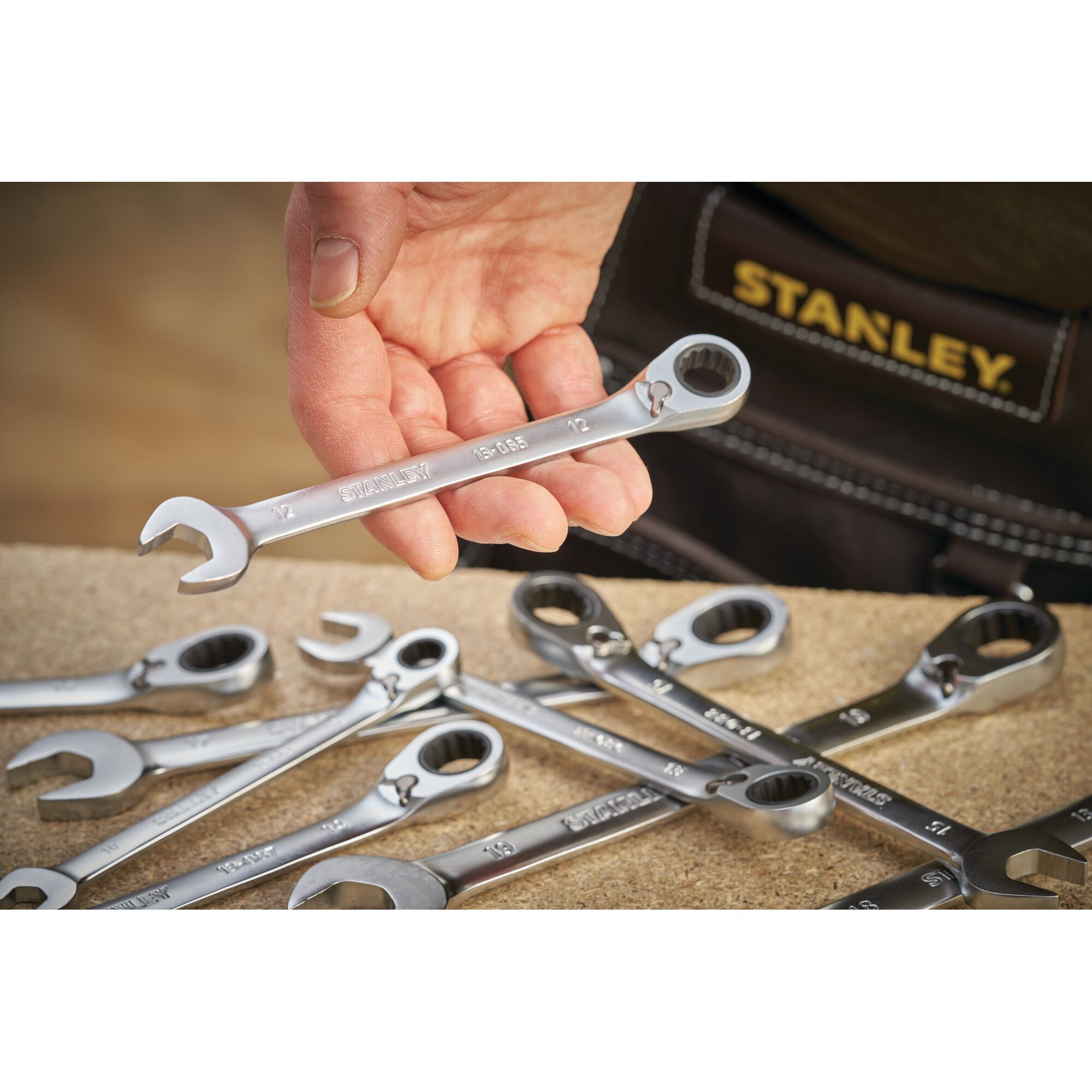 STANLEY FMMT13089-0 hand-held combination ratchet wrench set on workbench, close-up photo.