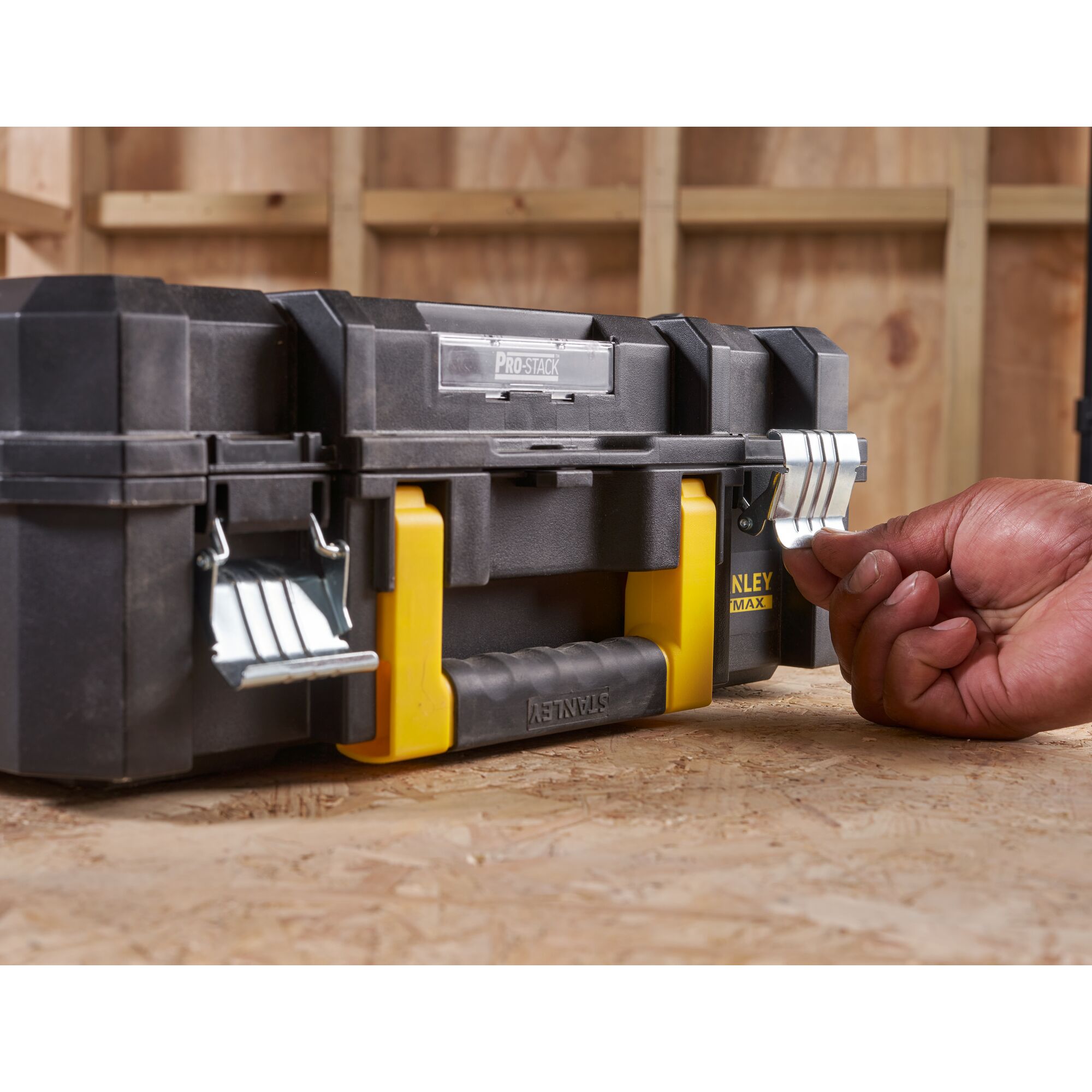 STANLEY FMST1-71966 toolbox with metal latches and yellow handle, front angle, hand unlocking latch.