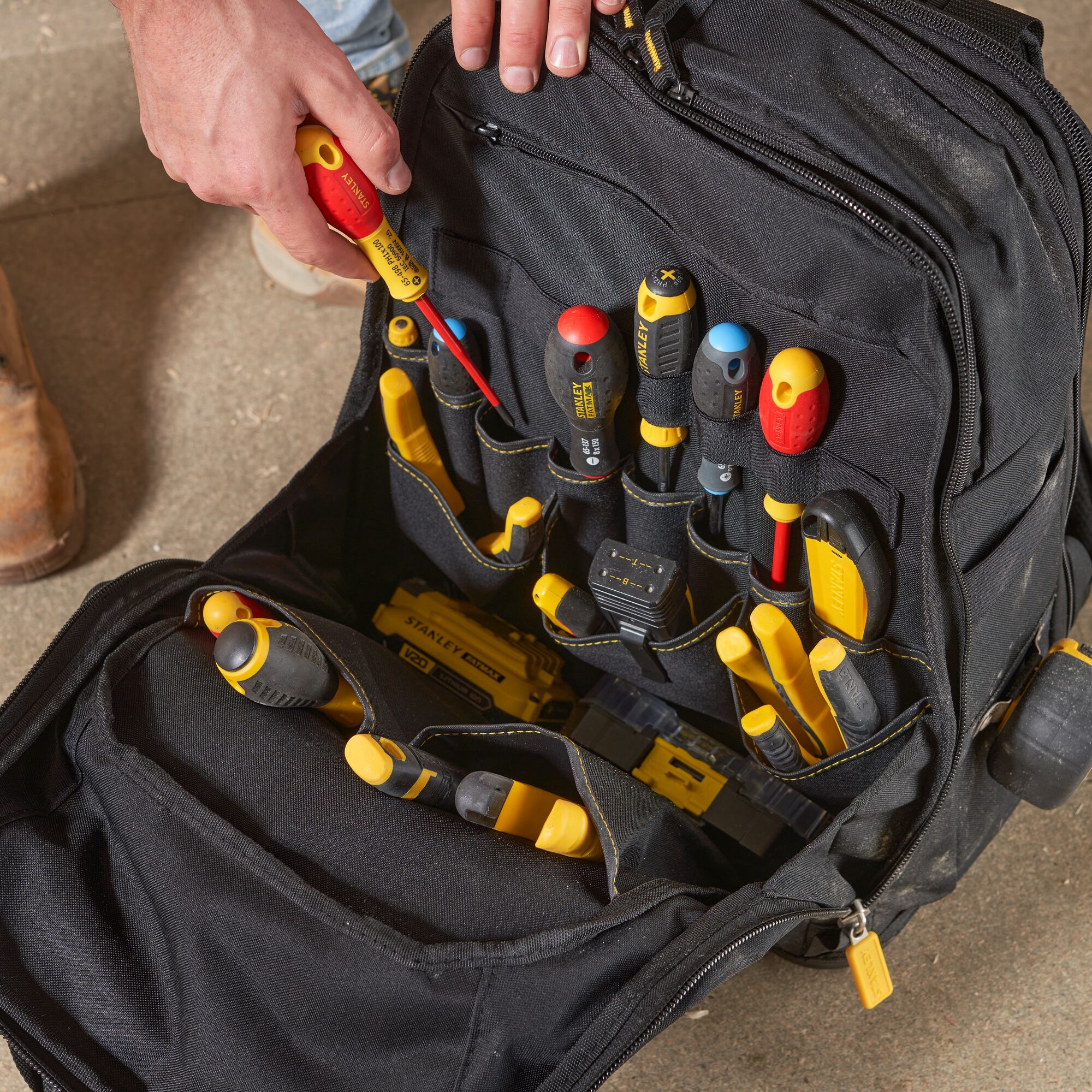 STANLEY FMST1-80144 tool backpack with organized hand tools in black and yellow, top view photo.