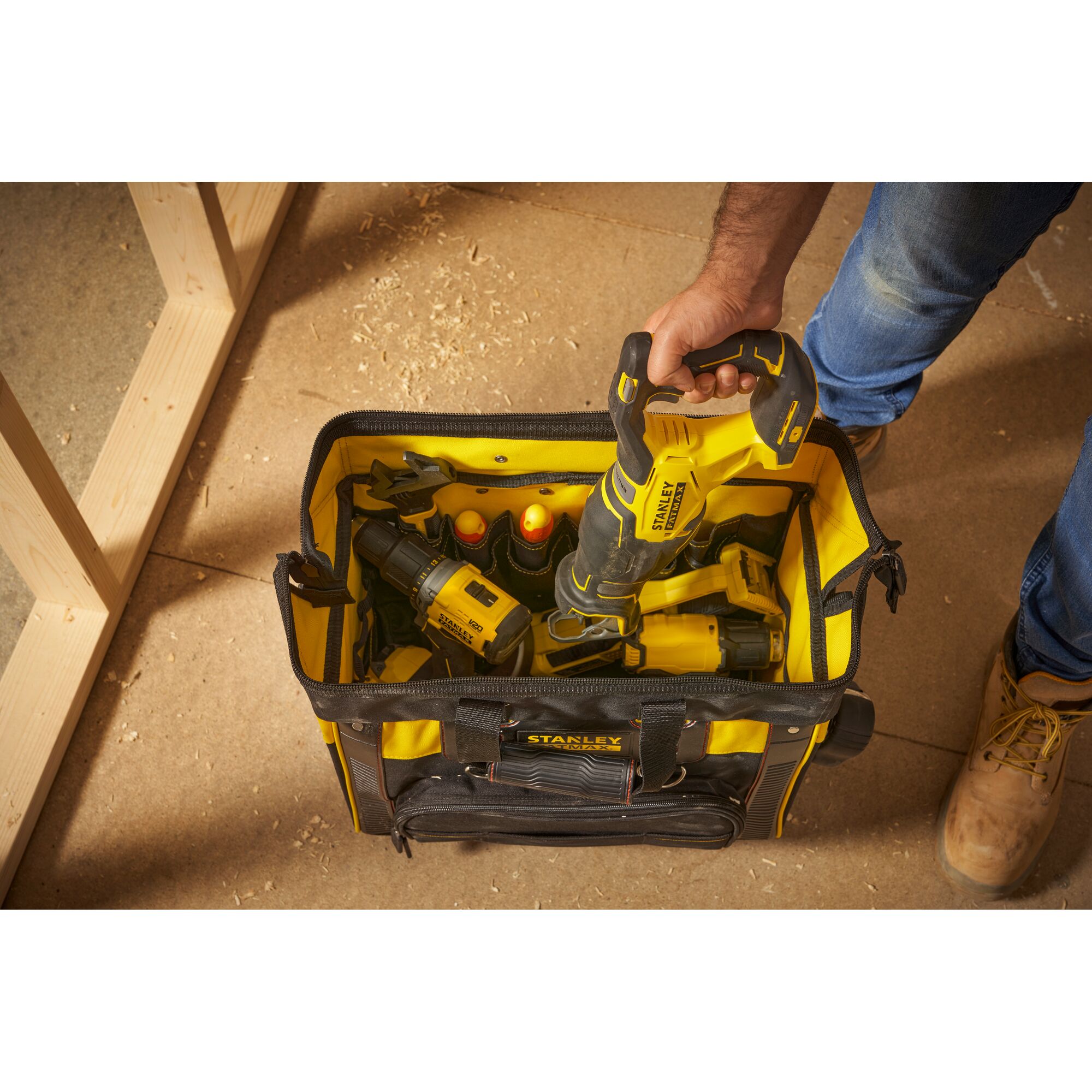 Photo of STANLEY FMST1-80148 tool bag filled with yellow-black power tools, viewed from above on a workshop floor.