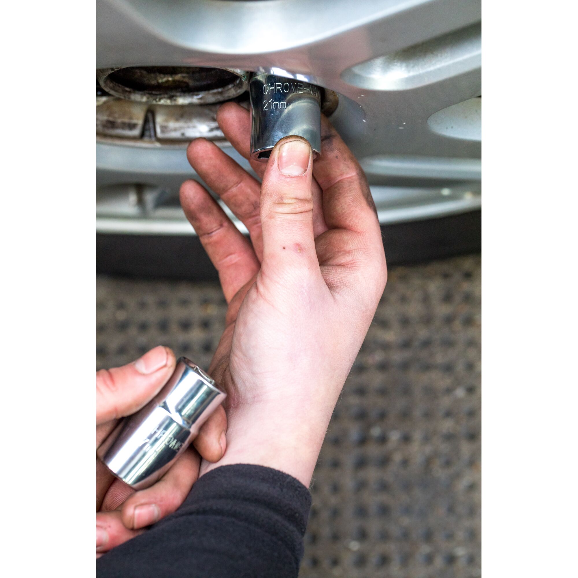 STANLEY STHT80890-0 socket being used to remove a car wheel nut, close-up hand view.