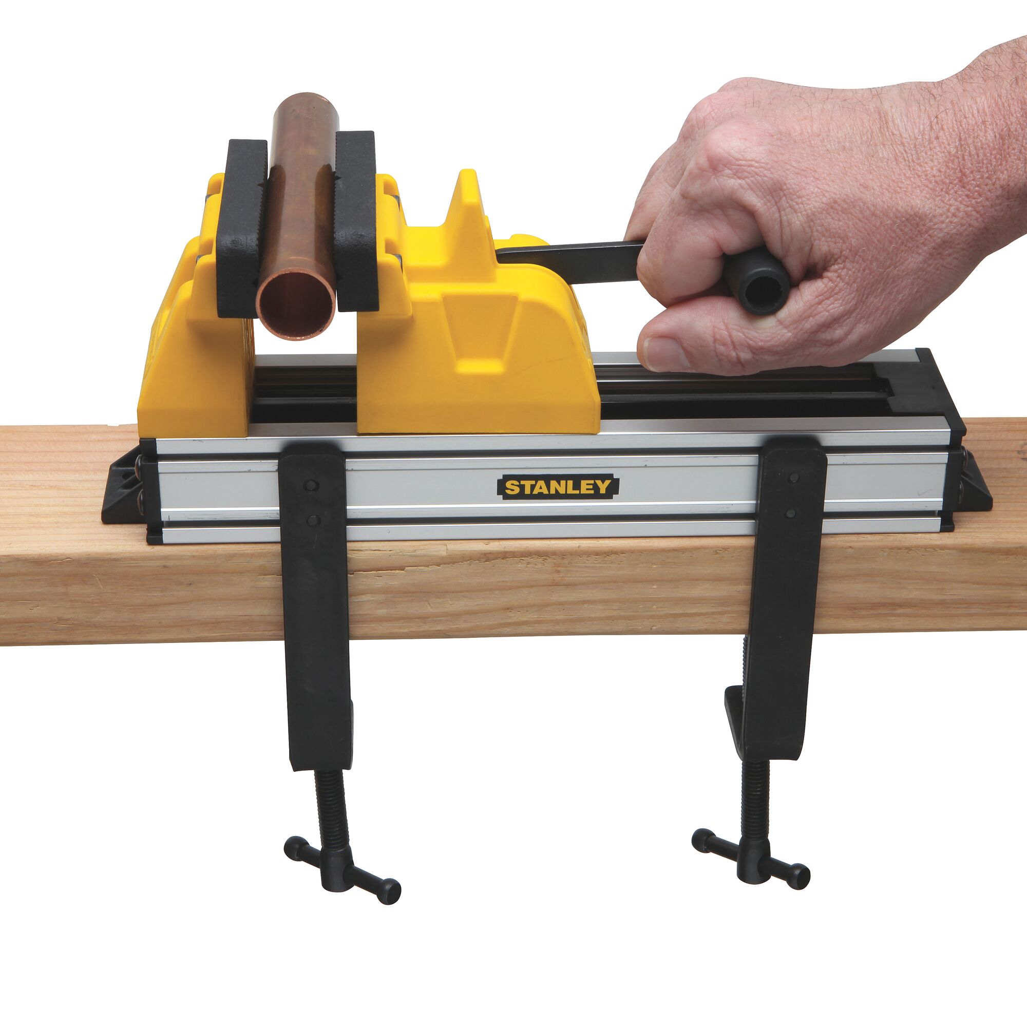 Stanley pipe vice with yellow and black jaws clamped to a wooden beam, holding a copper pipe, front angle