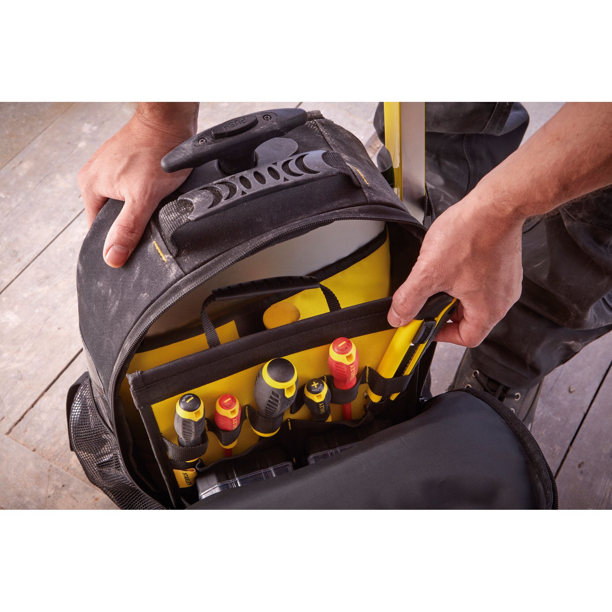 STANLEY STST83307-1 tool bag with multiple compartments and assorted hand tools, top view.